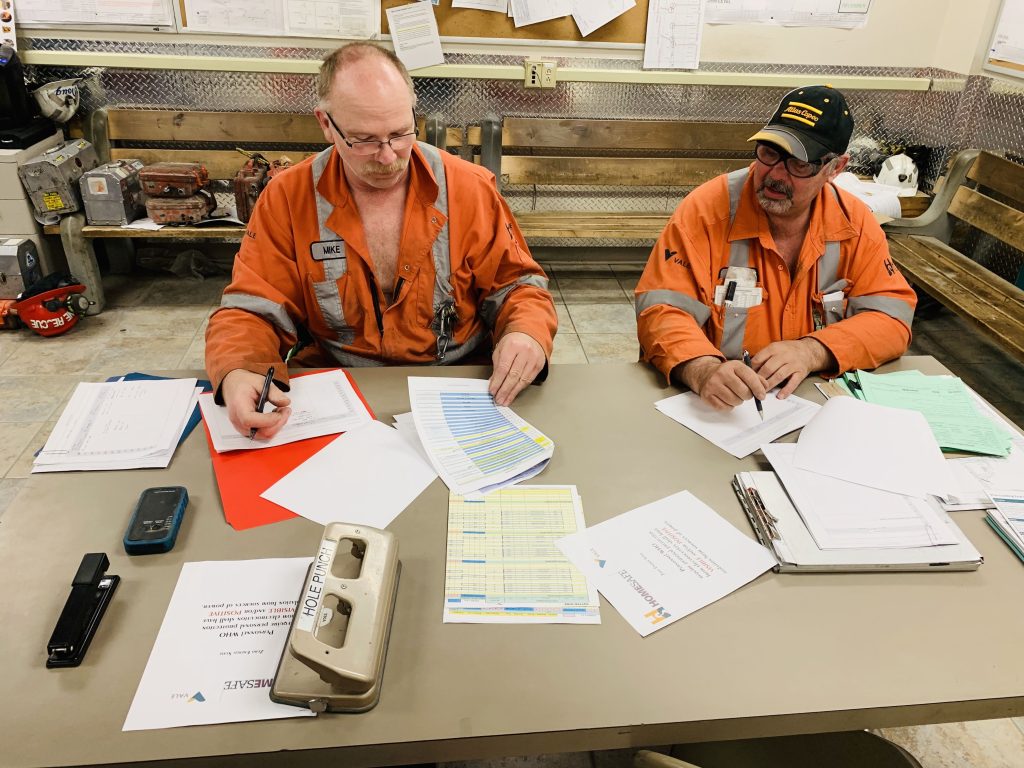 Production Supervisors reviewing prints outstanding line-ups from last night.